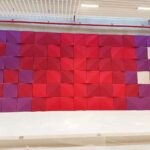 Custom-coloured acoustic 3D panels forming a decorative backdrop in lobby area