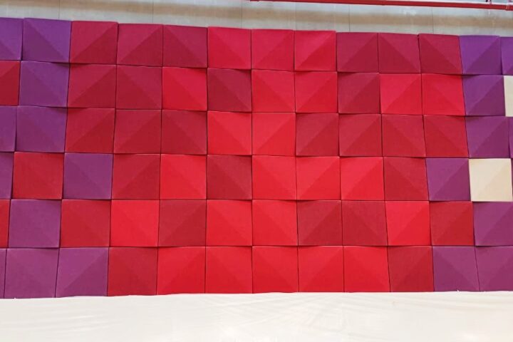 Custom-coloured acoustic 3D panels forming a decorative backdrop in lobby area
