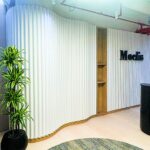 Curved DecraWave acoustic panels in modern commercial hallway