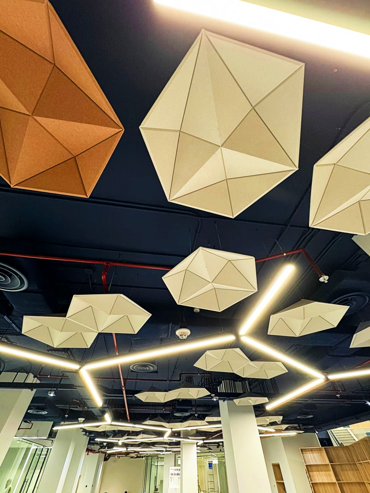 Geometric DecraCloud acoustic ceiling clouds suspended in a commercial office to reduce reverberation and improve acoustic comfort.