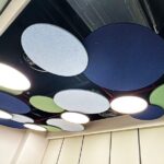 Faceted acoustic cloud ceiling system featuring geometric folded surfaces.
