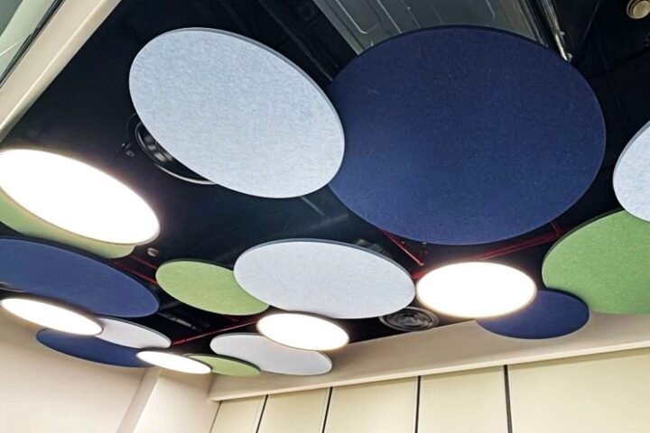 Faceted acoustic cloud ceiling system featuring geometric folded surfaces.