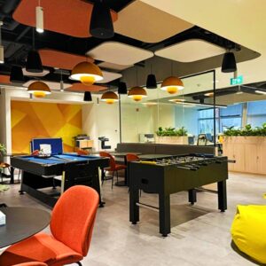 Decorative acoustic clouds suspended above a workplace breakout and recreation space.