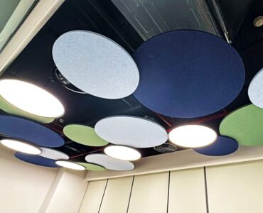 Faceted acoustic cloud ceiling system featuring geometric folded surfaces.